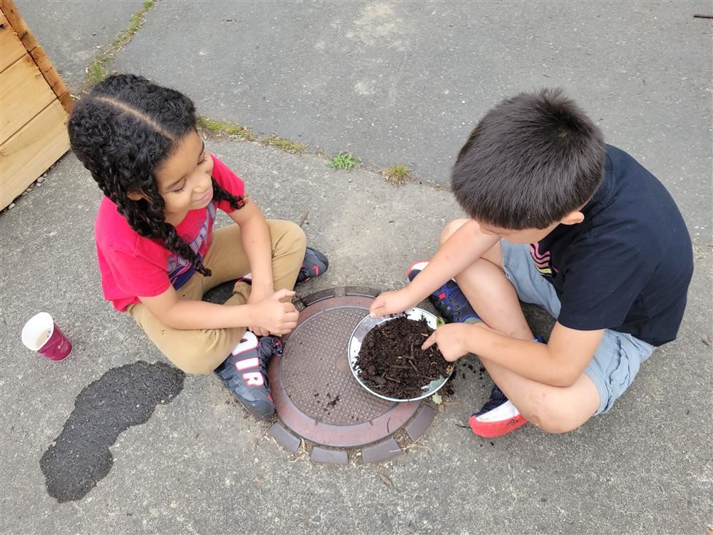 Two students sitting on the ground