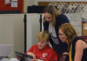 Students and instructor behind computer