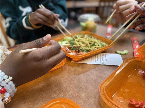student hands sharing food