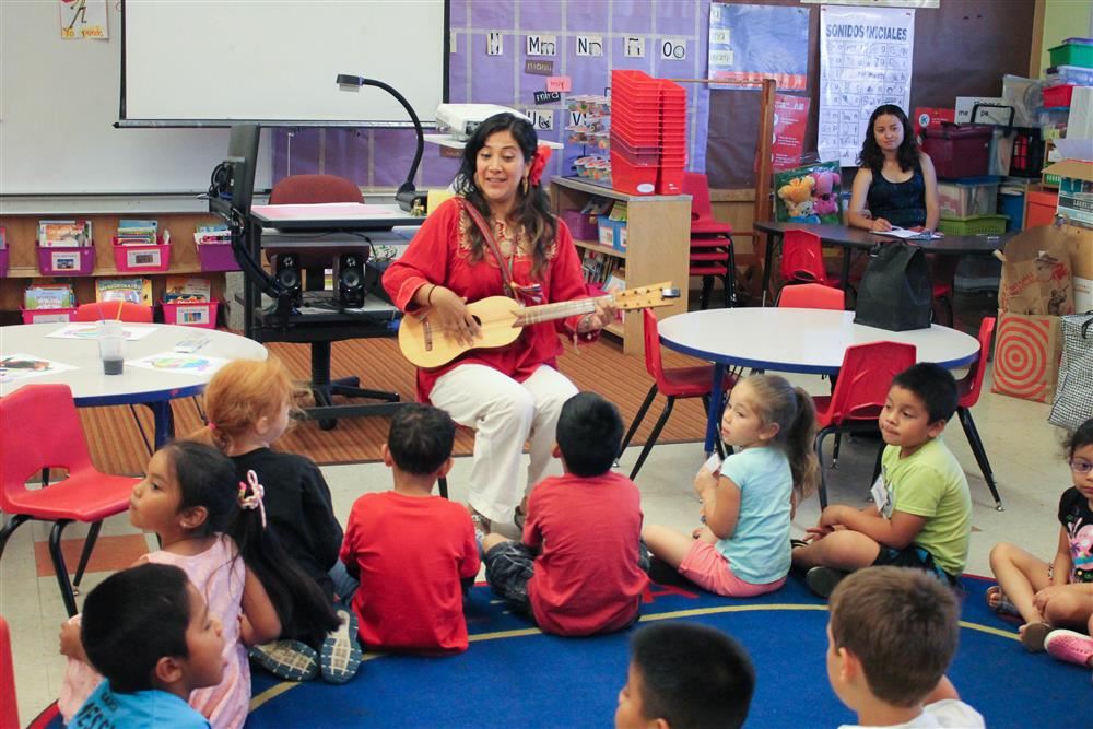 Teacher Amparo Garcia-Yurchenco plays guitar for Rigler Teacher Amparo Garcia-Yurchenco plays guitar for Rigler