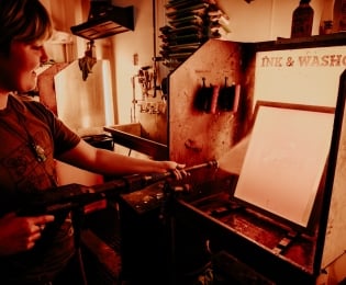 Student spaying an ink and wash station