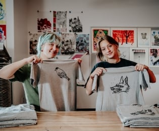Students holding up screen print shirts