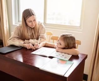 A teenage student mentoring a younger child