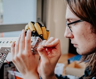 Male student working on small electronics