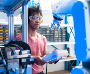 Student controlling a large robotic arm