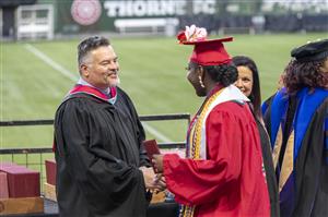 Superintendent Guadalupe Guerrero congratulating a McDaniel student at graduation.