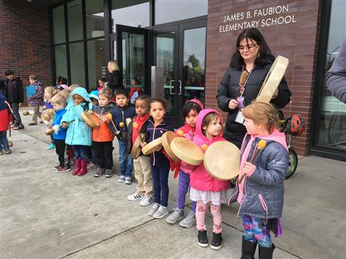 Students cheer on community marchers with drums 