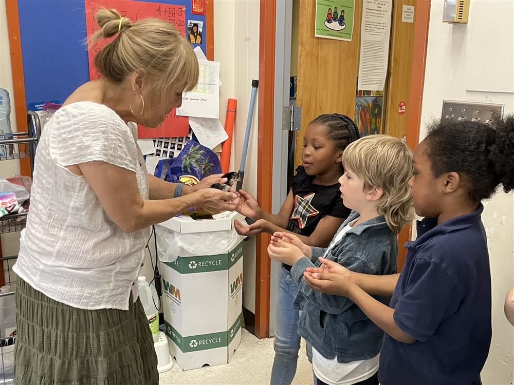 Miss Ellie helps students hold a chick.