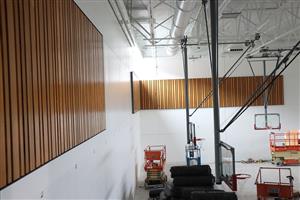 salvaged bleacher wood installed on new Gym walls 