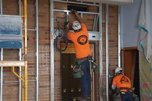 Two workers performing seismic wall framing work at Creative Science