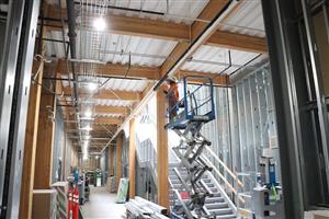 Wide hall with framing & workers