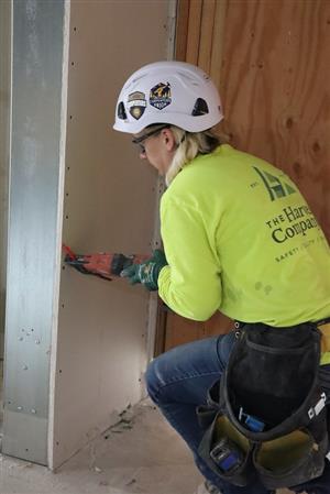 Female construction worker installs panel