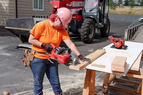 Construction worker sawing wood